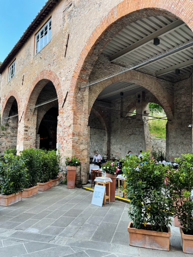 Blick auf die Außenterrasse der Trattoria Da Giulio unter alten Gewölbebogen. Ein wunderschönes Restaurant.