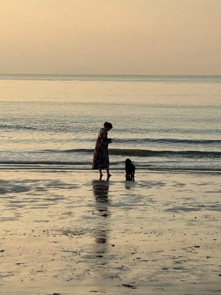 Hund Fritte und ich bei Sonnenuntergang am Meer.